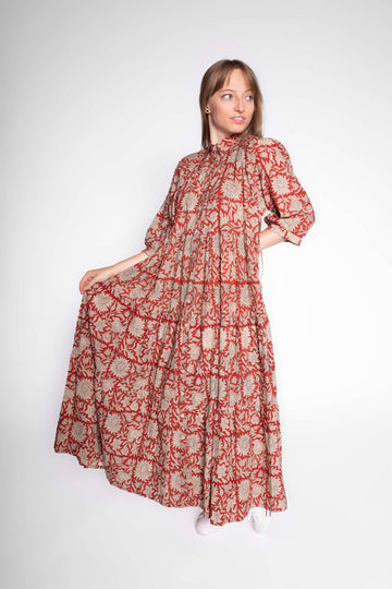 Woman wearing a long, block print cotton aline patterned dress on a white background